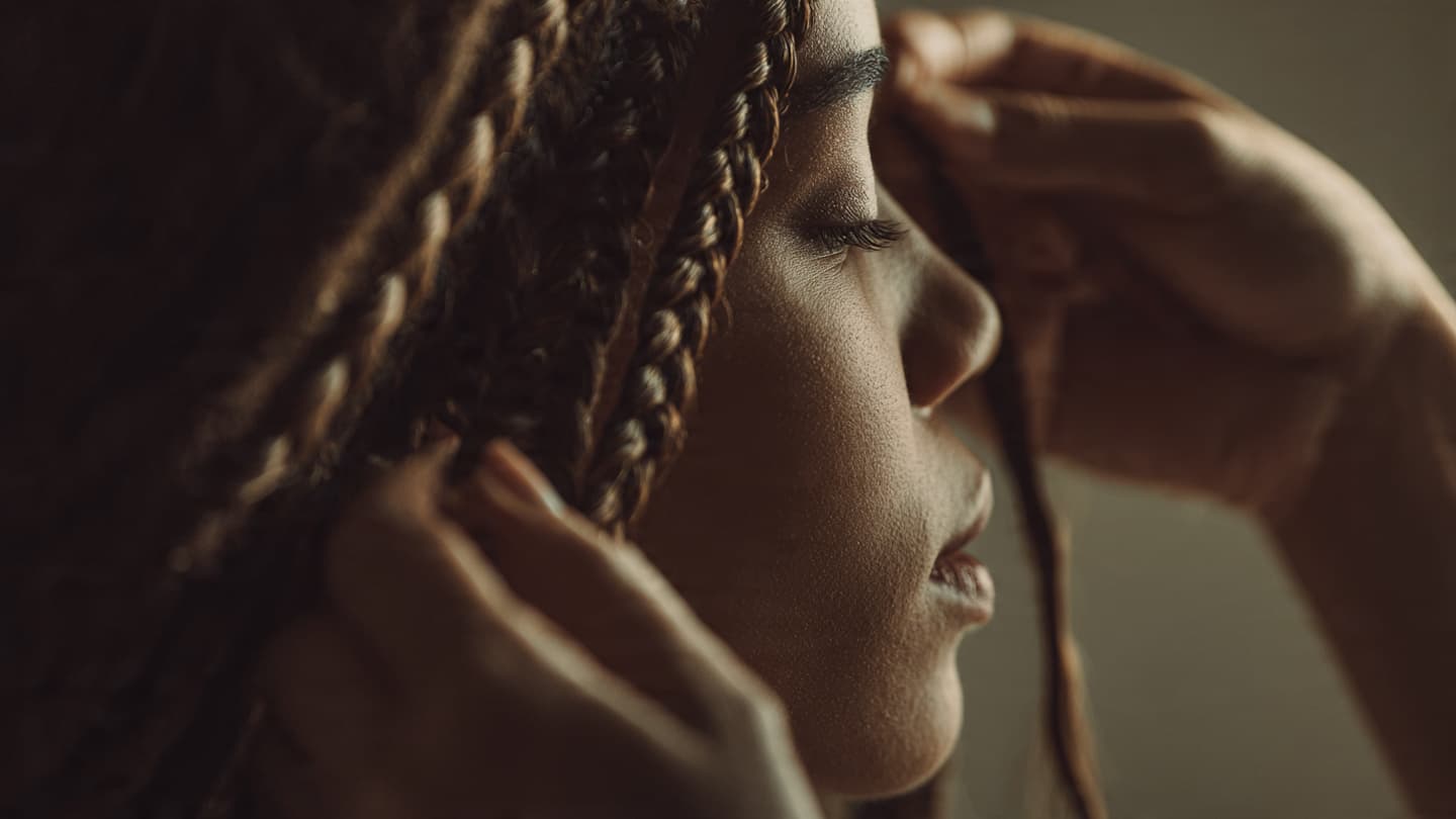 Close-up of meticulously crafted box braids with natural hair texture, showing precise parting and healthy installation under soft studio lighting
